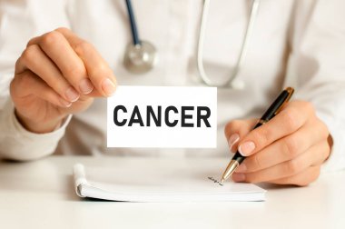 Kanser kartı tıp doktorunun elinde. Doktorun ellerinde bir kağıt parçası var. Metin kanseri, tıbbi konsept..