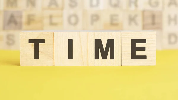 Słowo Time Jest Napisane Drewnianych Kostkach Jasnożółtej Powierzchni Tle Rzędy — Zdjęcie stockowe