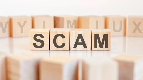 Scam - word on wooden cubes on white background — Stock Photo, Image