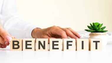 Ofis masasında BENEFIT harfleri bulunan tahta bloklar, bilgi ve iletişim geçmişi, ofis işyeri üzerine seçici odaklanma