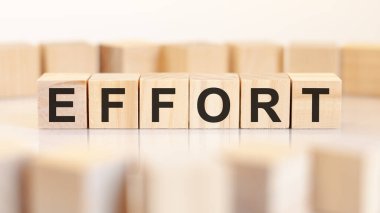 EFFORT - ofis masasında ahşap harfler, beyaz arka plan, iş konsepti.