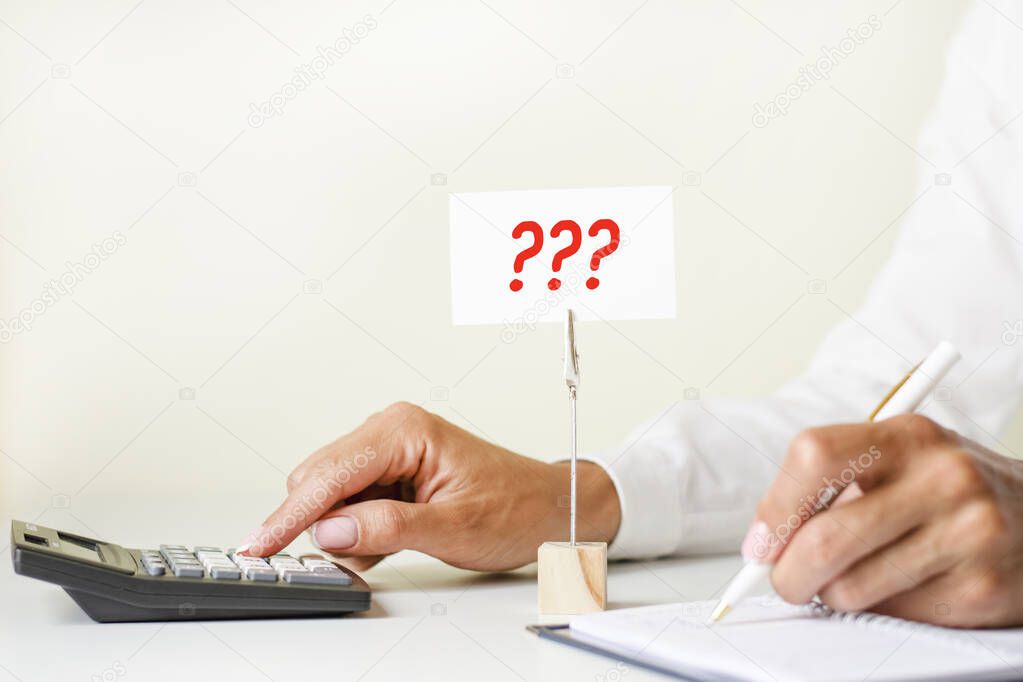 text writing hree question marks written on the white paper card