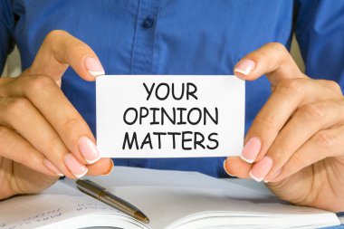 Kadının elinde bir kartvizit var. Üzerinde 