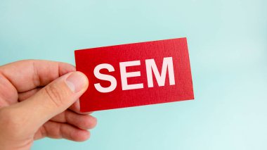İş adamının elinde, kırmızı karttaki SEM mesajı. Finans konsepti. SEM - Arama Motoru Pazarlamanın kısaltması