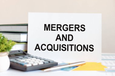 Metin birleşmeleri ve satın almaların yer aldığı beyaz kağıt parçası, kitapların arka planına karşı, seçici odaklı.