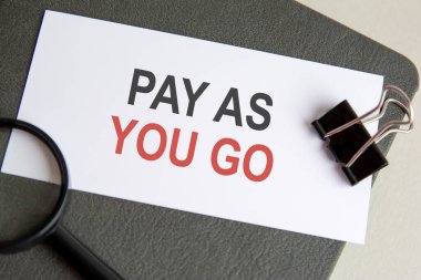 Kağıt ve büyüteç için klip ve gri arkaplan ile deftere yazılan metni öde