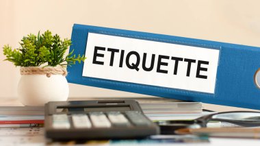ETIQUETTE - mavi klasör hesap makinesi, kalem ve yeşil saksı bitkisi ile ofis masasında. İş, finans, eğitim, denetim ve vergi kavramları için kullanılabilir. Seçici odak.
