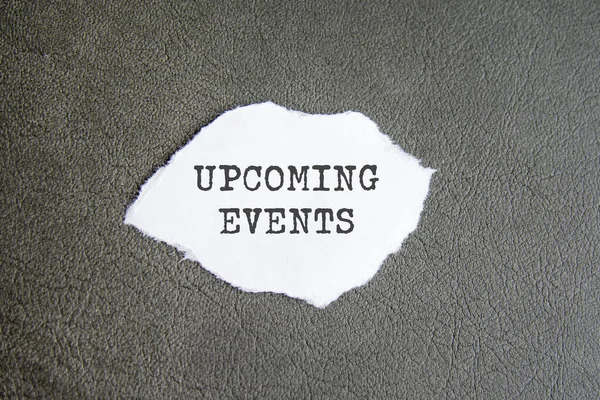 upcoming events sign on the torn paper on the grayy background.