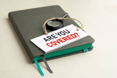 Gri defterde bir büyüteç ve üzerinde yazı olan beyaz bir kağıt var. Kapalı mısın, seçici odaklı mısın?