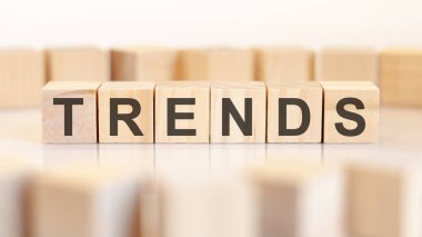 Kelime trendleri bir sırada duran tahta küplere yazılır. Arka planda harfler olan blokların etrafında. İşletme ve finansal kavramlar için kullanılabilir. seçici odak.