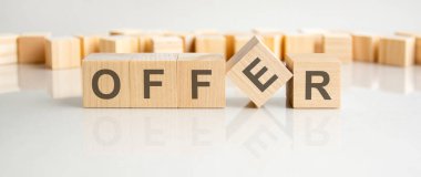 Teklif: Gri arka planda harfleri olan tahta bloklar. Tablonun aynalı yüzeyindeki başlığın yansıması. Seçici odak.