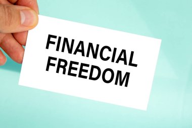 Metin finansal özgürlüğe sahip el ele kağıt kartviziti, yakın plan açık gri arka plan, iş konsepti