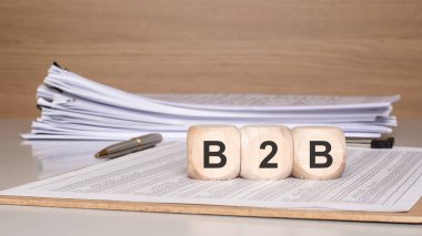 İş 'ten İş B2B' ye konsepti. Tahta bloklar kalem ve kağıt destesiyle B2B 'nin finansal belgelerde yazılışını engelliyor. Şirket satışları, ortaklıklar ve ticaret temaları için ideal.