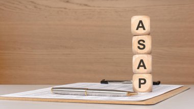 Dik duran tahta oyuncak blokları en kısa sürede mali raporları ve kalemle birlikte bir masanın üzerine yazılıyor. Acil görevler, zaman yönetimi, hızlı kurumsal kararlar, son teslim tarihleri ve acil iş faaliyetleri kavramı. I 'nin sol tarafında bir sürü kopya alanı var.