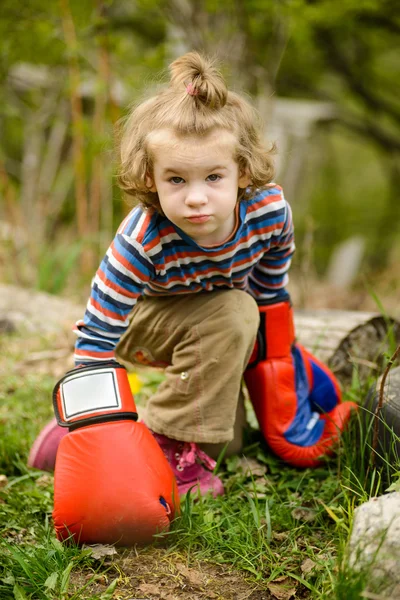 Little girl in red boxing gloves