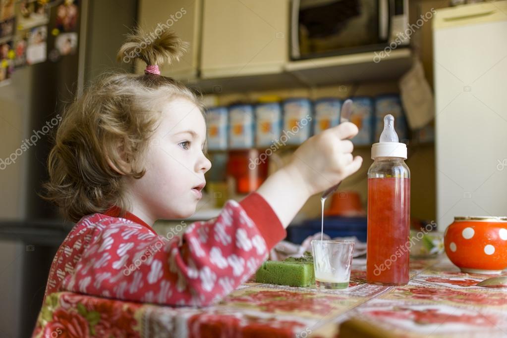 Child eat condensed milk in kitchen — Stock Photo © 0sArt #72513479