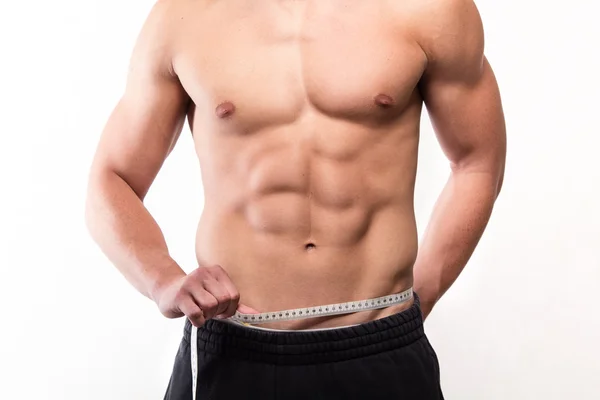 Muscular fitness man measuring his waist — Stock Photo, Image