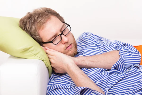 Junger Mann schläft auf der Couch — Stockfoto