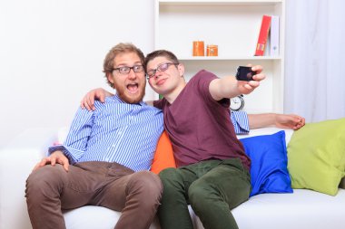 İki arkadaş kanepede selfie yapıyor 