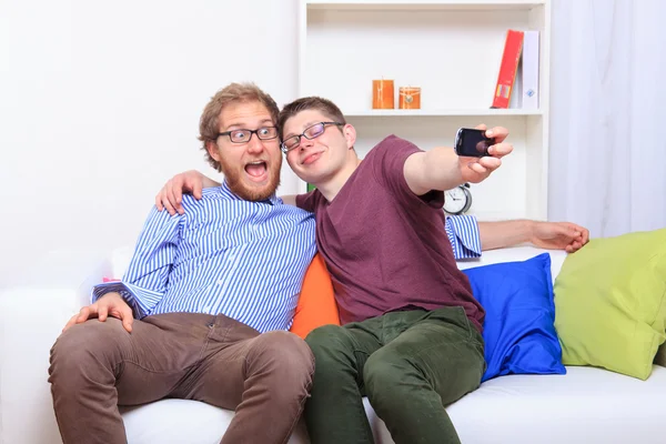 Dos amigos haciendo selfie en el sofá — Foto de Stock