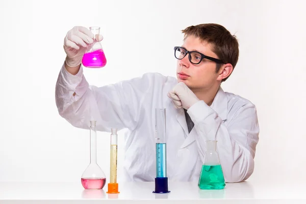 Chemist looks at the glass in the lab — Stock Photo, Image