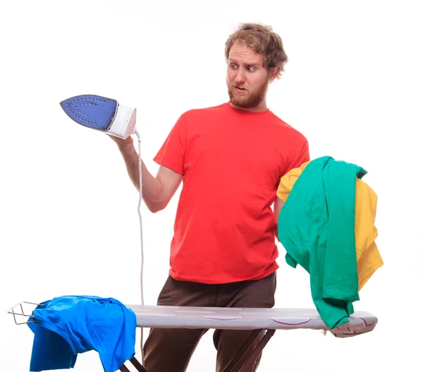 Verlegener Mann bügelt Kleidung an Bord — Stockfoto