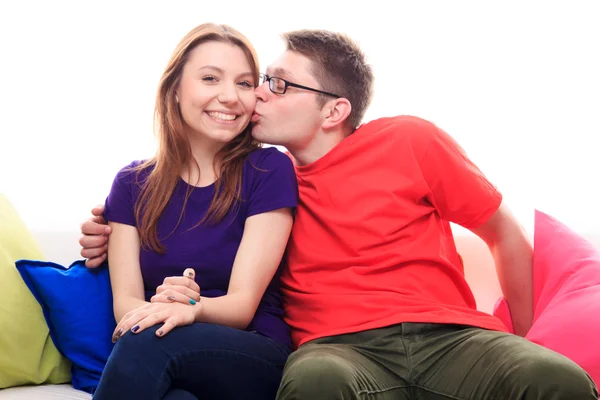 Menino beijando uma menina no sofá em casa — Fotografia de Stock