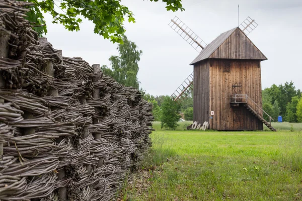 Houten molen en gevlochten hek op het platteland — Stockfoto