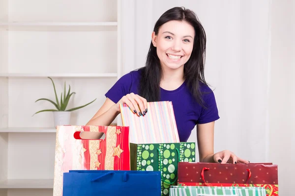 Sorridente ragazza felice prepara borse regali per Natale — Foto Stock