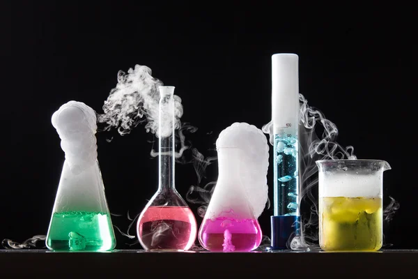 Glass in a chemical laboratory filled with colored liquid during — Stock Photo, Image