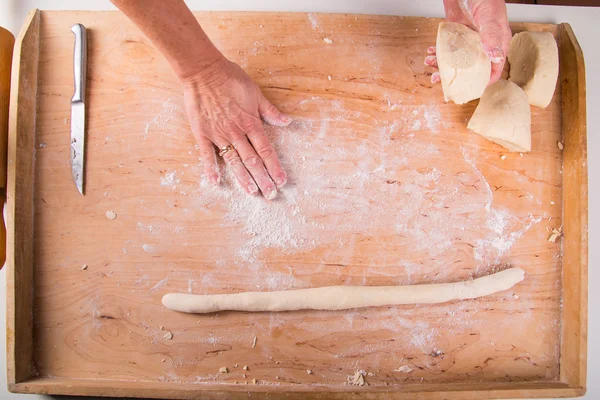 Rolling out the dough on a board in the kitchen — Stock Photo, Image