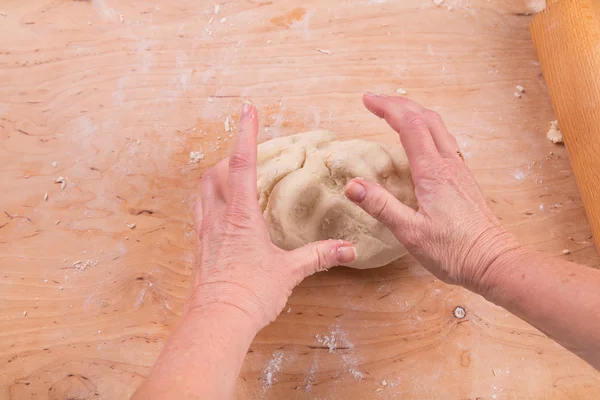 Hands kneading dough on board — Stock Photo, Image
