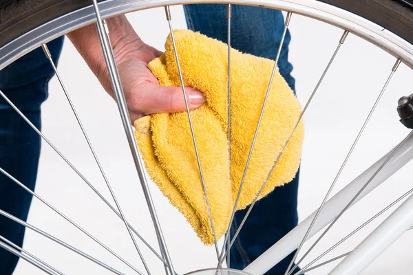 Cleaning bicycle spokes in the wheel with a cloth — Stock Photo, Image