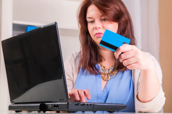 Mulher que paga com cartão de crédito usando um computador e a Internet em — Fotografia de Stock