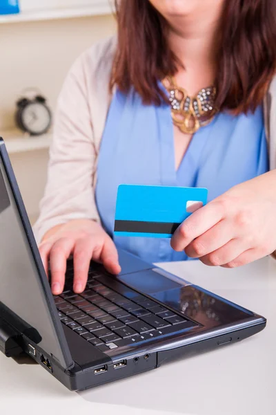 Vrouw betaalt met credit card via een computer en het Internet in — Stockfoto