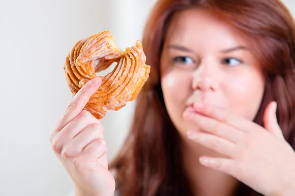 Tombul ve mutlu kadın masada donut yemek — Stok fotoğraf