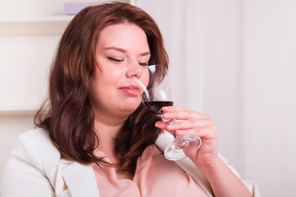 Femme élégante teste un verre de vin rouge — Photo