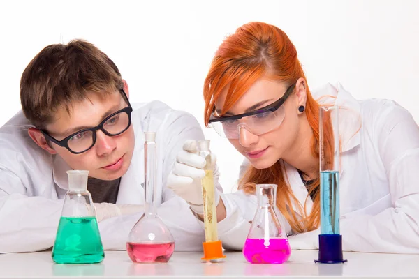 Dois estudantes em laboratório de química fazendo reações — Fotografia de Stock