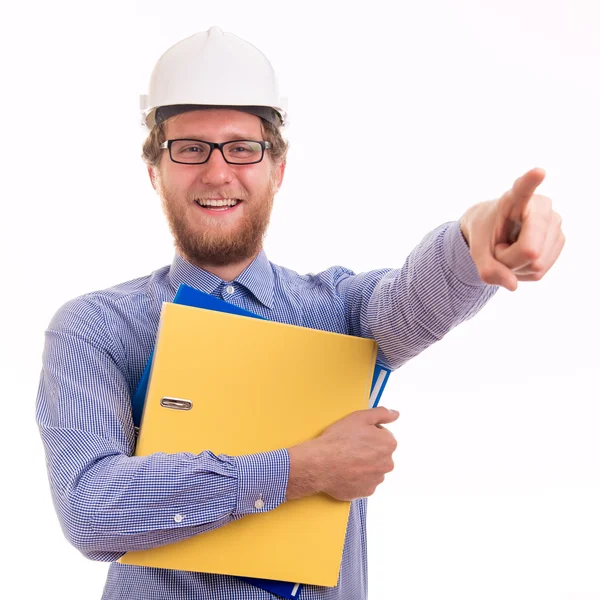 Молодой счастливый инженер в шлеме показывает пальцем — стоковое фото