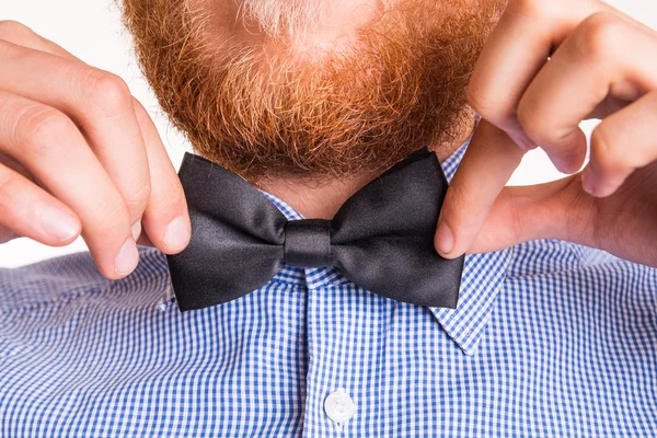 Bearded man ties a bow tie at the collar — Stock Photo, Image