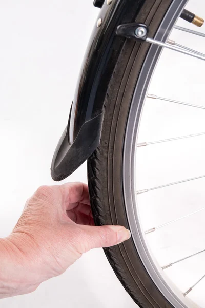 Hand checks the amount of air in a bicycle whee — Stock Photo, Image