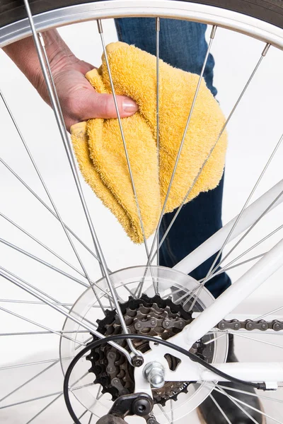 Cleaning bicycle spokes in the wheel with a cloth — Stock Photo, Image