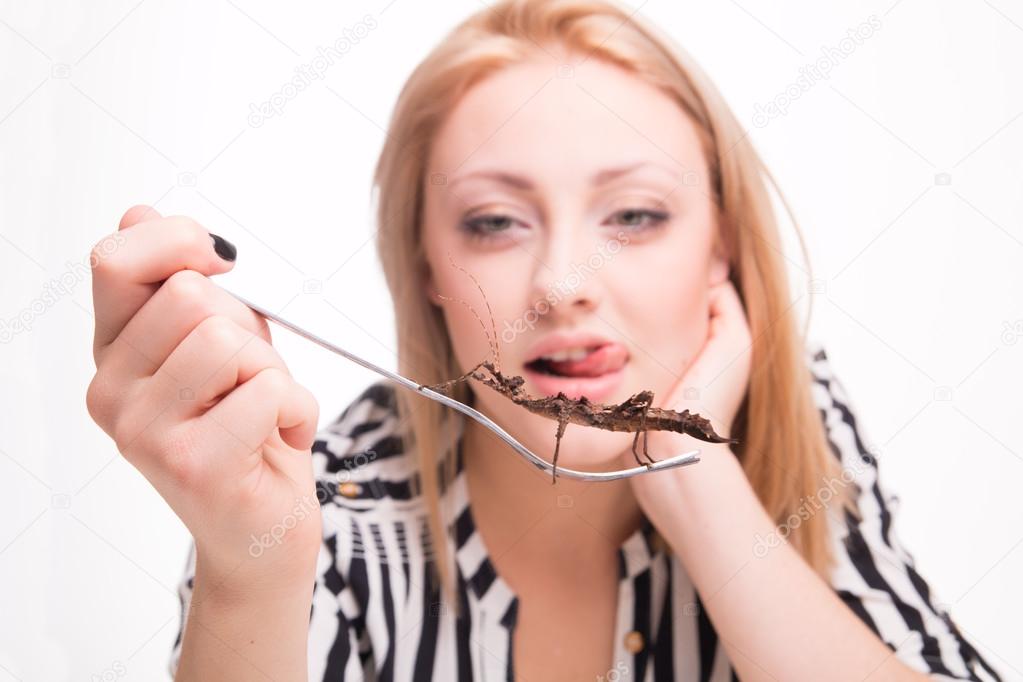 Joyful woman eating insects