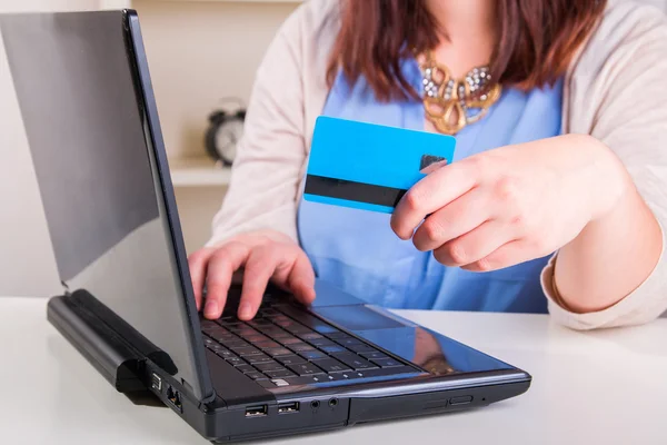 Vrouw betaalt met credit card via een computer en het Internet in — Stockfoto