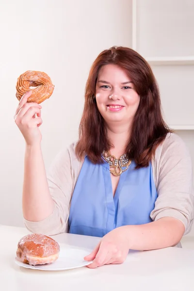 Knubbig kvinna anläggning donut — Stockfoto