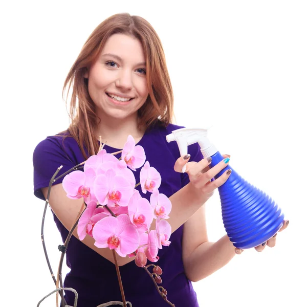 Красивая девушка поливает цветы орхидеи — стоковое фото