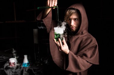 Alchemist in chemical laboratory prepares magical liquids clipart