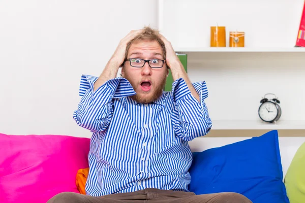 Hombre sorprendido en sofá — Foto de Stock