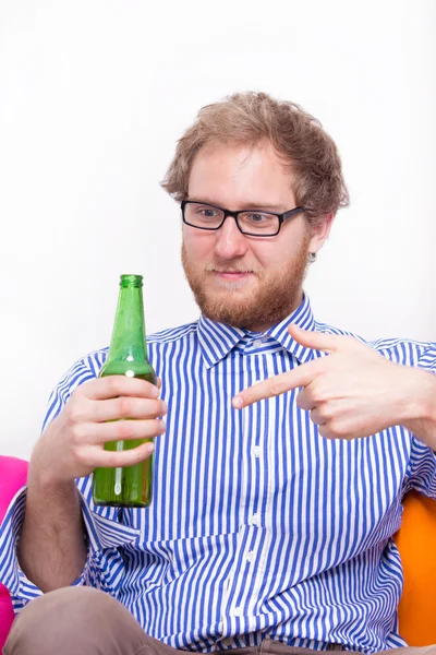 Bearded man pointing at beer bottle — Stock Photo, Image