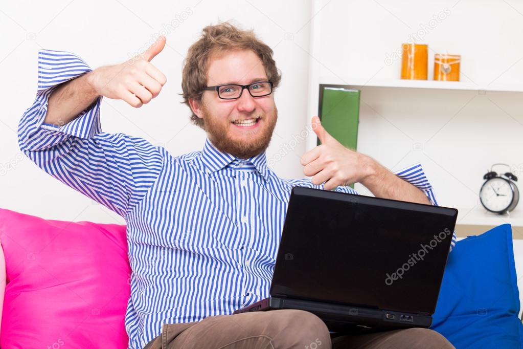 man with laptop showing OK signs 